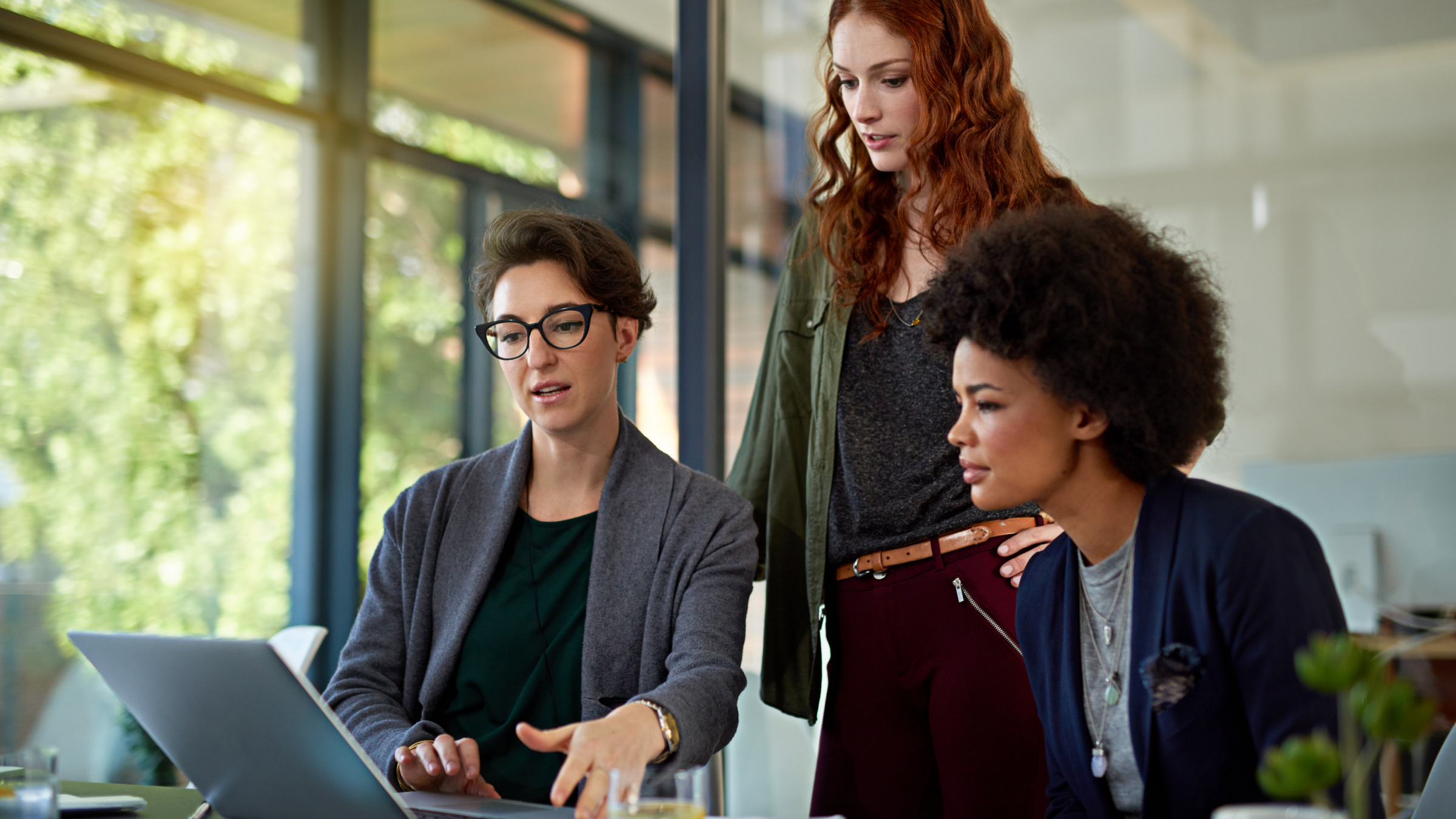 Three women looking at a computer screen.