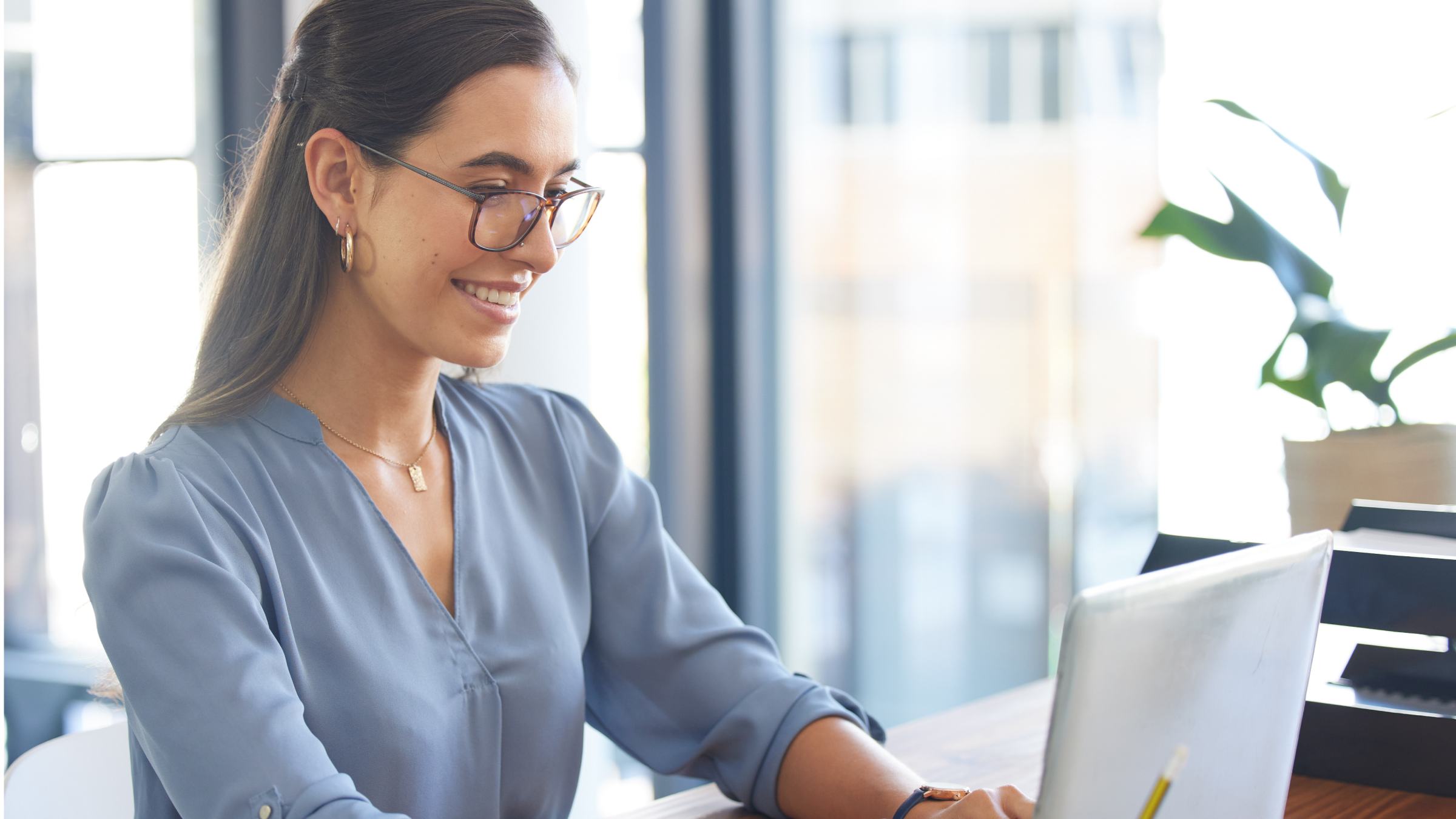 A woman smiling at her computer.